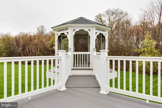 wooden deck with a lawn and a gazebo