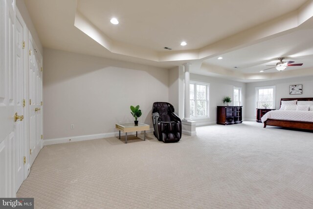 carpeted bedroom with baseboards, decorative columns, a tray ceiling, and recessed lighting