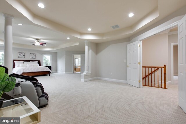 carpeted bedroom featuring visible vents, a raised ceiling, baseboards, ornate columns, and recessed lighting