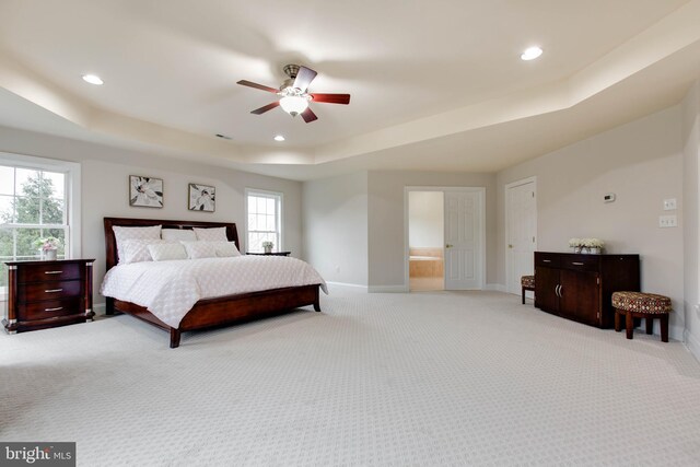 bedroom with a raised ceiling, baseboards, recessed lighting, and light colored carpet