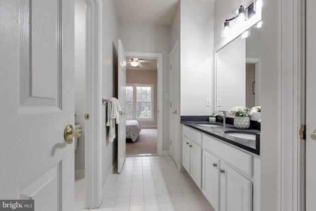 ensuite bathroom with double vanity, a ceiling fan, tile patterned flooring, a sink, and ensuite bath