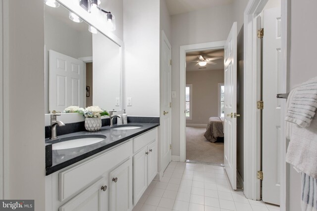 ensuite bathroom with a sink, a ceiling fan, ensuite bath, and double vanity