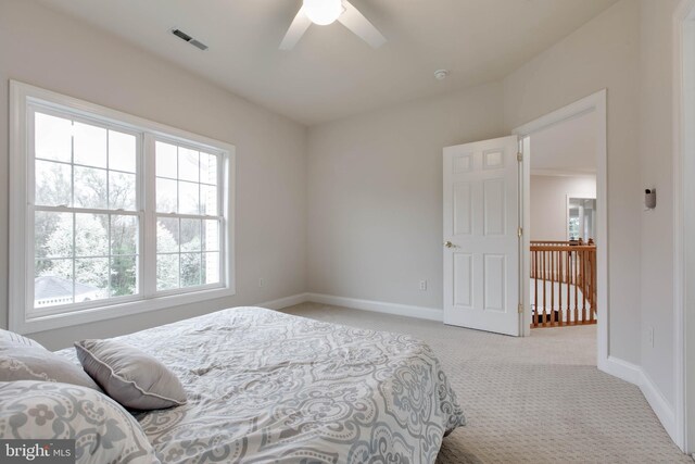 bedroom with light colored carpet, baseboards, ceiling fan, and visible vents