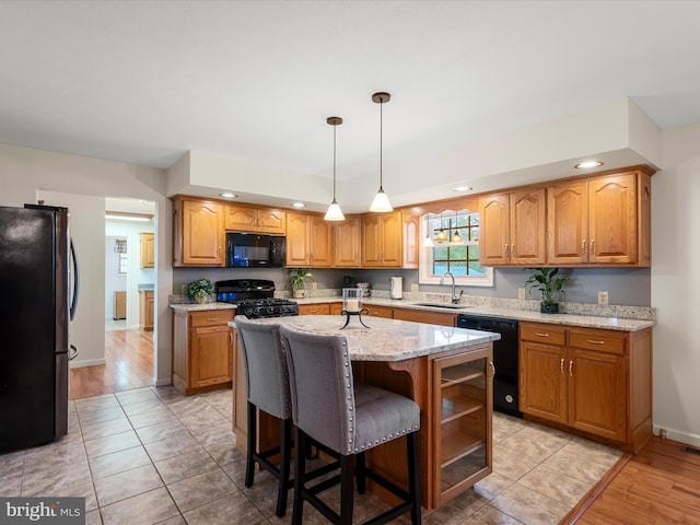 5409 Smith Creek Rd, New Market, VA 22844 - kitchen with a kitchen island with sink, light stone counters, a sink, and black appliances