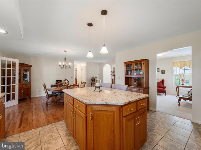 5409 Smith Creek Rd, New Market, VA 22844 - kitchen featuring brown cabinets, an inviting chandelier, arched walkways, a center island, and pendant lighting