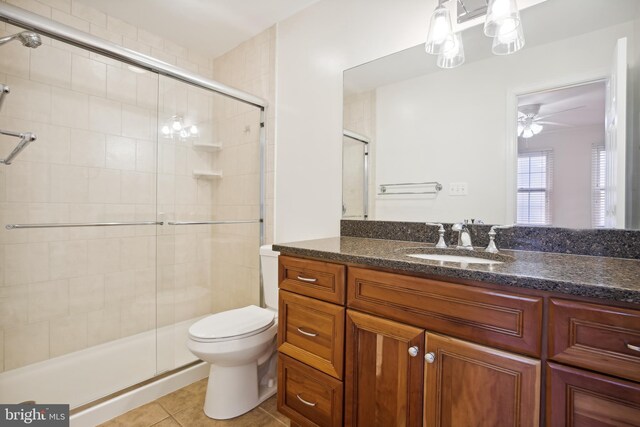 full bathroom with a shower stall, tile patterned floors, toilet, and vanity