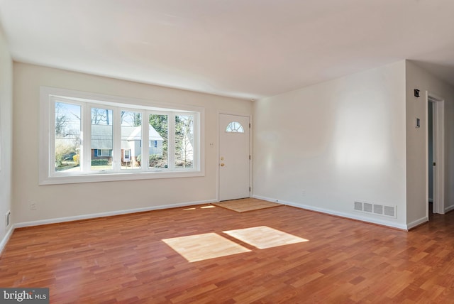 foyer with baseboards, visible vents, and light wood-style floors