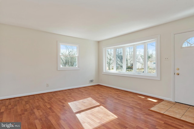 entrance foyer with baseboards, visible vents, and wood finished floors