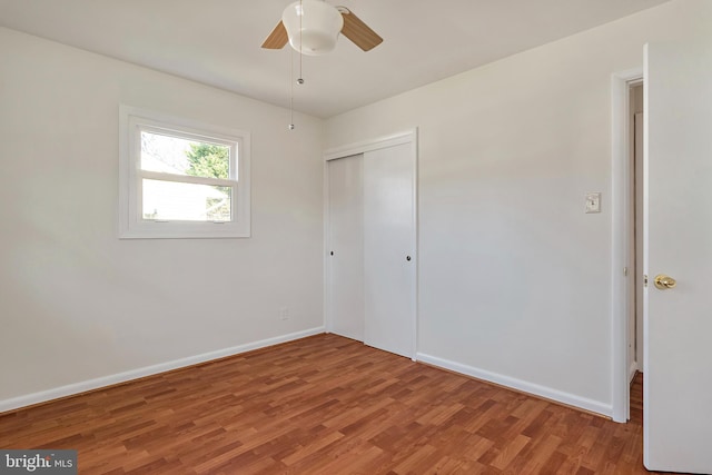 unfurnished bedroom with baseboards, ceiling fan, light wood-style flooring, and a closet