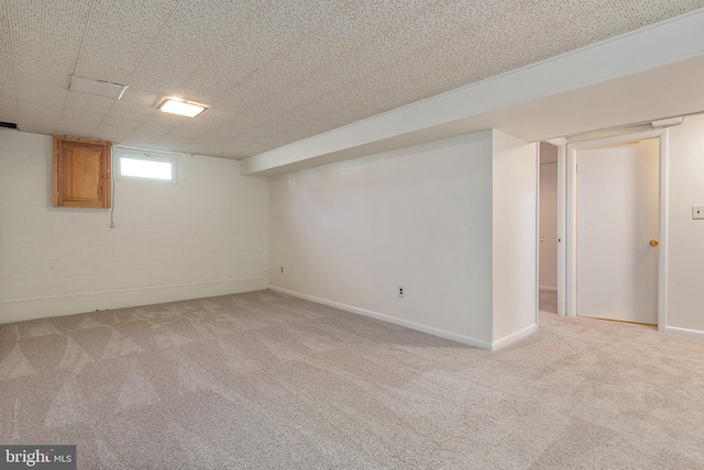 below grade area with concrete block wall, carpet, and baseboards