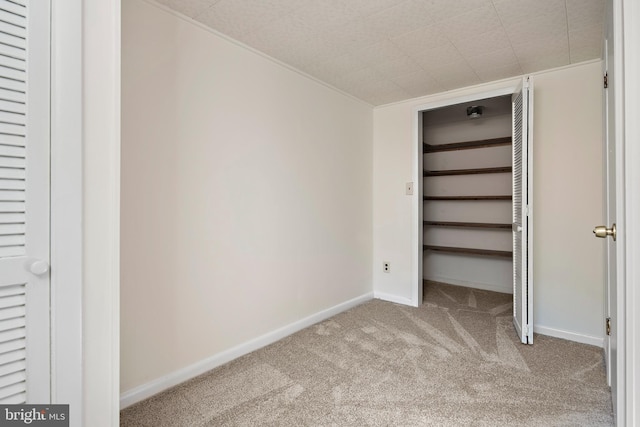 unfurnished bedroom with baseboards, carpet floors, and a spacious closet