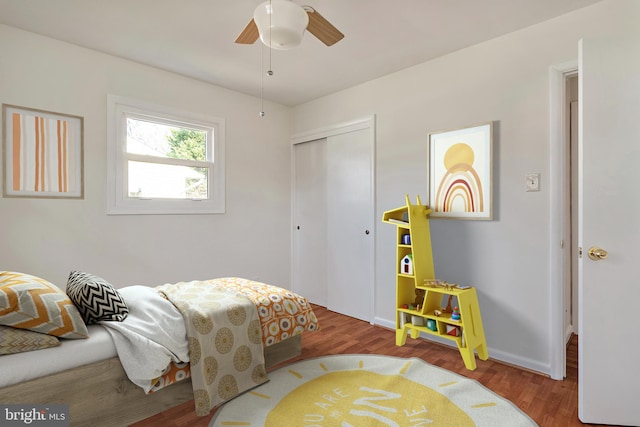 bedroom with baseboards, a closet, wood finished floors, and ceiling fan