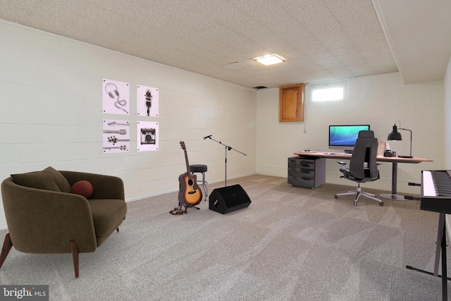 home office featuring concrete block wall and light colored carpet