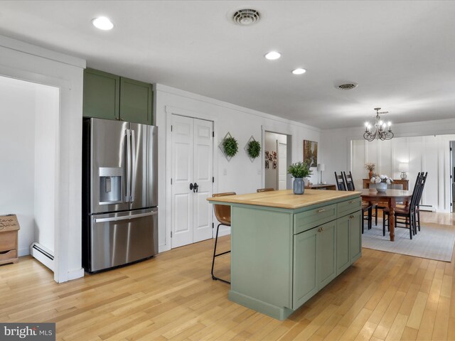 kitchen with stainless steel fridge with ice dispenser, green cabinets, and light wood-type flooring