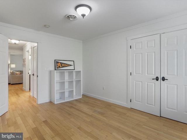 interior space with light wood finished floors, baseboards, and visible vents
