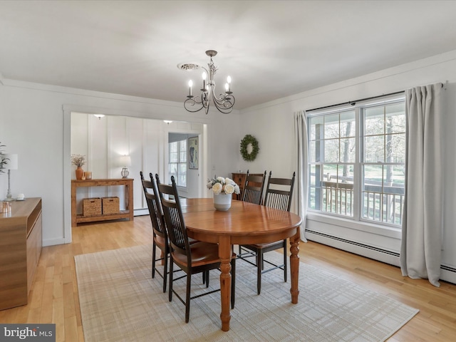 dining room with a baseboard radiator, a notable chandelier, crown molding, and light wood finished floors