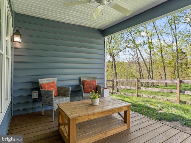 wooden terrace with ceiling fan and fence