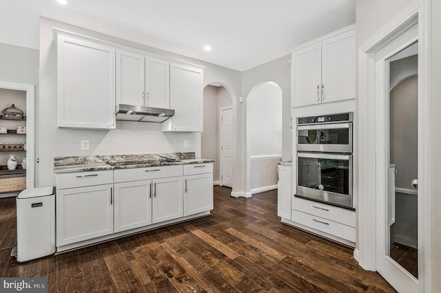 630 Good Shepherd Way, Owings, MD 20736 - kitchen with under cabinet range hood, arched walkways, black electric cooktop, white cabinetry, and dark wood-style floors