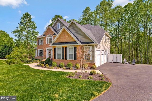 630 Good Shepherd Way, Owings, MD 20736 - view of front facade featuring a front lawn, a gate, driveway, brick siding, and a garage