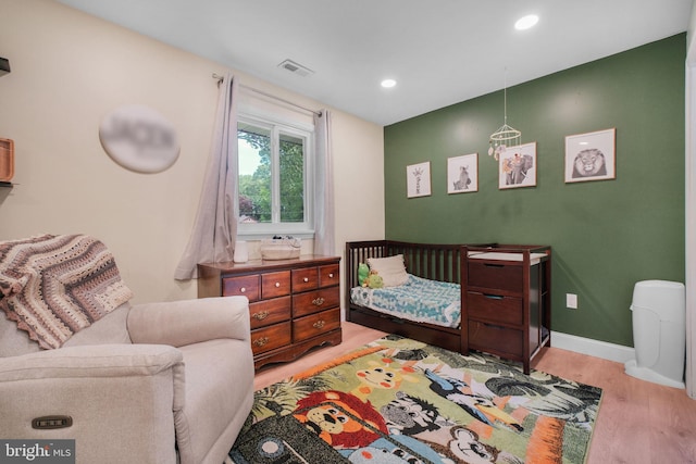bedroom featuring wood finished floors, recessed lighting, and baseboards
