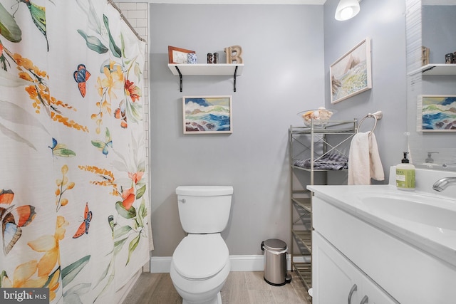 bathroom with toilet, vanity, baseboards, wood finished floors, and a shower with curtain