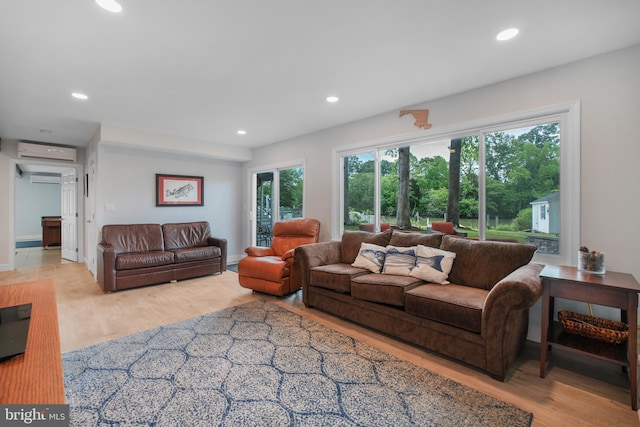 living area with a wall unit AC, wood finished floors, and recessed lighting