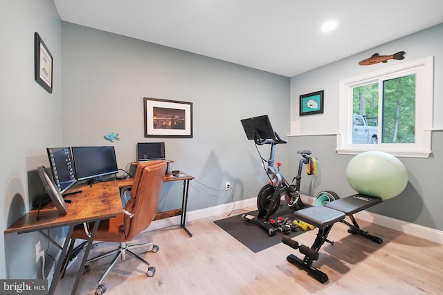 exercise room featuring wood finished floors and baseboards
