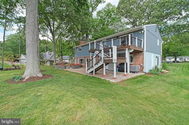 rear view of house featuring a patio, a deck, cooling unit, and a lawn