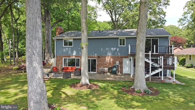 back of property with an outdoor hangout area, a chimney, a patio area, brick siding, and a yard