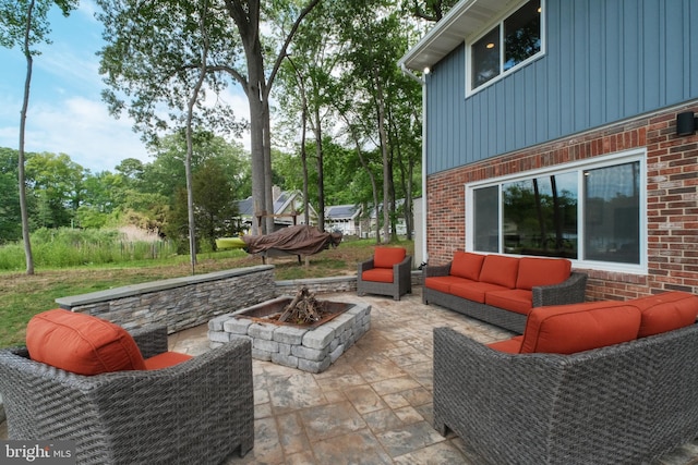 view of patio with an outdoor living space with a fire pit