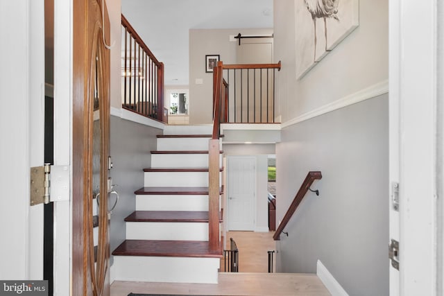 stairs with healthy amount of natural light and a high ceiling