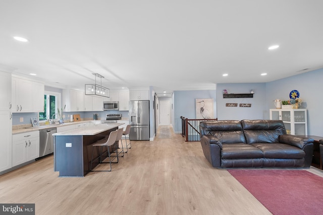 living room with recessed lighting, light wood-style floors, and baseboards