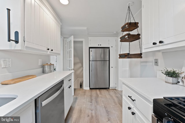 9301 Mintwood St, Silver Spring, MD 20901 - kitchen with light countertops, white cabinetry, appliances with stainless steel finishes, and light wood finished floors
