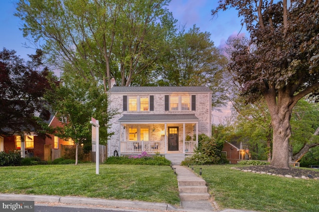 9301 Mintwood St, Silver Spring, MD 20901 - traditional home featuring covered porch, a chimney, brick siding, and a front yard