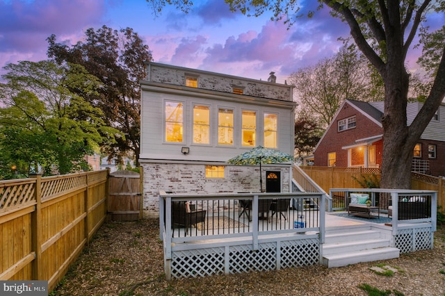 9301 Mintwood St, Silver Spring, MD 20901 - back of house at dusk featuring a fenced backyard, a gate, a deck, and brick siding