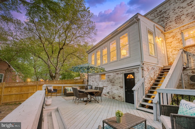 9301 Mintwood St, Silver Spring, MD 20901 - deck at dusk featuring an outdoor hangout area, a fenced backyard, outdoor dining area, and stairway
