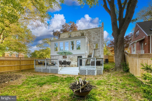 9301 Mintwood St, Silver Spring, MD 20901 - back of property featuring a fenced backyard, a wooden deck, a lawn, and stone siding