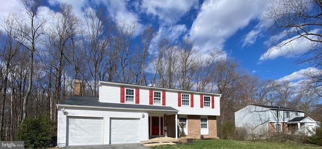 10808 Timberline Dr, Upper Marlboro, MD 20772 - view of front of home featuring a front yard, a chimney, an attached garage, brick siding, and aphalt driveway
