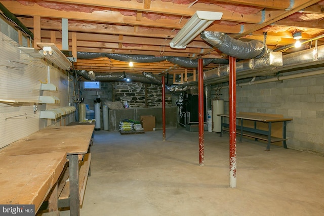 unfinished below grade area featuring heating unit, concrete block wall, and gas water heater