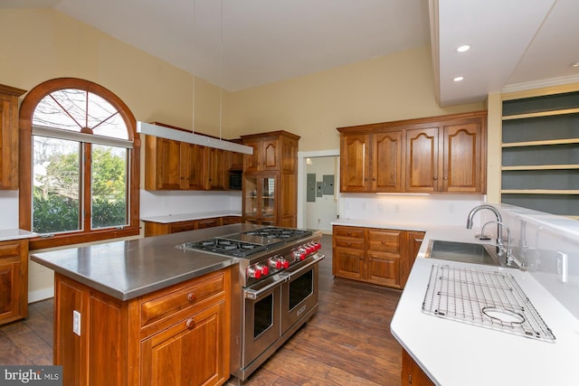 kitchen featuring a kitchen island, brown cabinetry, double oven range, and a sink