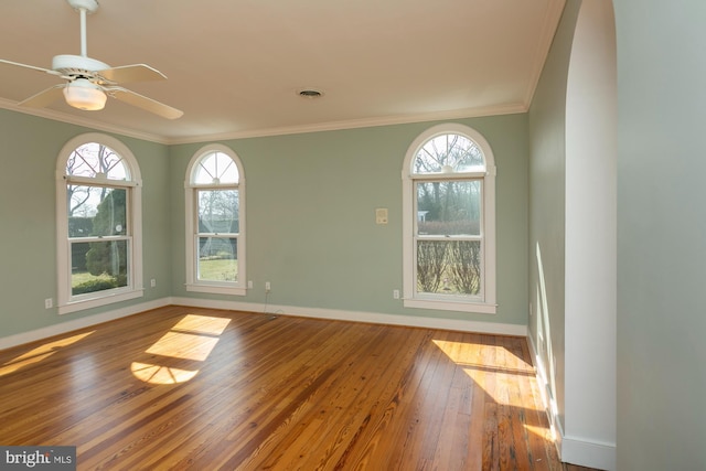 empty room with wood-type flooring, baseboards, visible vents, and a wealth of natural light