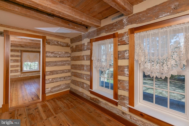unfurnished room with wooden ceiling, wood-type flooring, beam ceiling, and visible vents