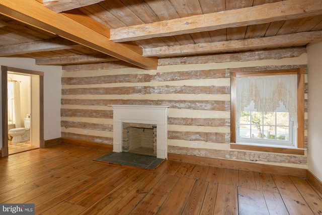 unfurnished living room featuring wood ceiling, baseboards, beamed ceiling, and hardwood / wood-style flooring