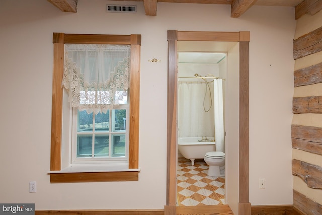 full bath featuring visible vents, curtained shower, a soaking tub, and beamed ceiling