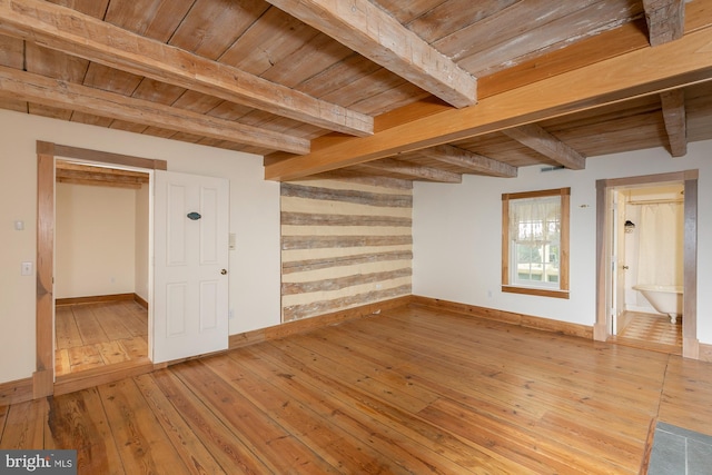 unfurnished room featuring baseboards, wooden ceiling, beam ceiling, and light wood-type flooring