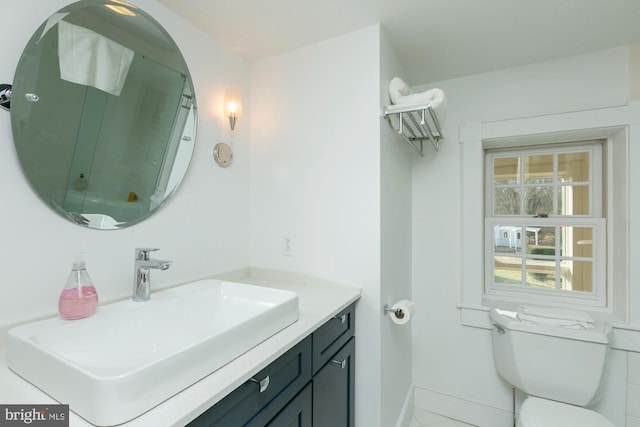 bathroom with baseboards, toilet, and vanity