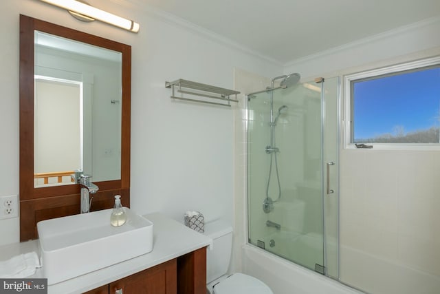 full bathroom featuring vanity, enclosed tub / shower combo, ornamental molding, and toilet