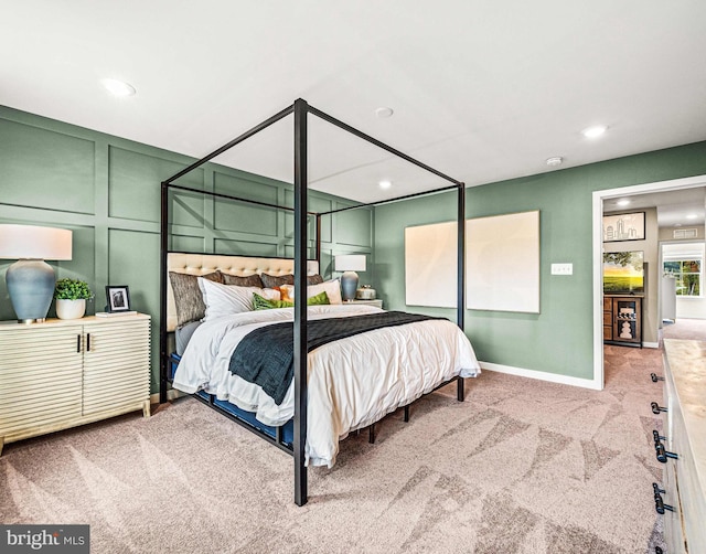 carpeted bedroom with baseboards, recessed lighting, and a decorative wall