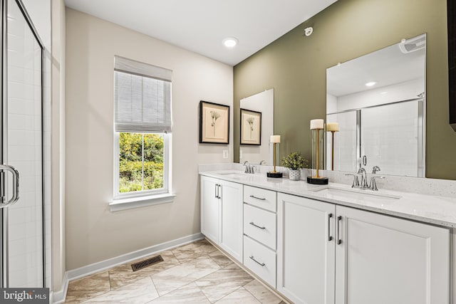 bathroom featuring a sink, a shower stall, baseboards, and visible vents