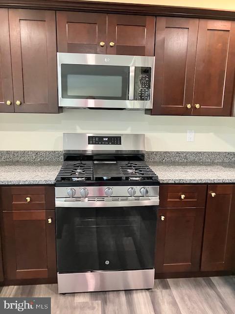 113 Heulings Ave, Riverside, NJ 08075 - kitchen with light wood-style floors, light stone counters, dark brown cabinetry, and stainless steel appliances